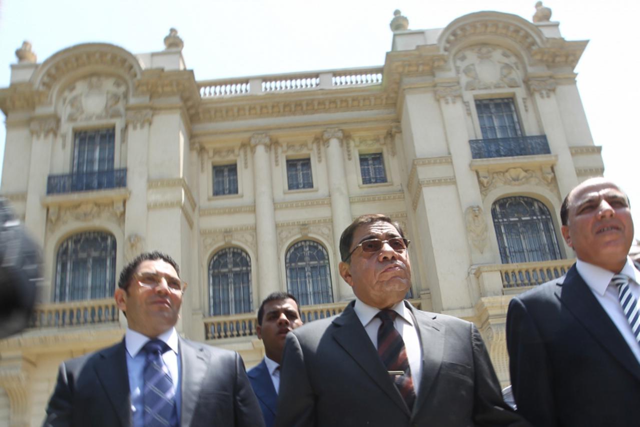 'Egypt\'s Prosecutor General Abdel Meguid Mahmud (C) leaves after speaking to journalists following his inspection of the Mohammed Mahmoud Khalil Museum (background) in Cairo on August 22, 2010, a day