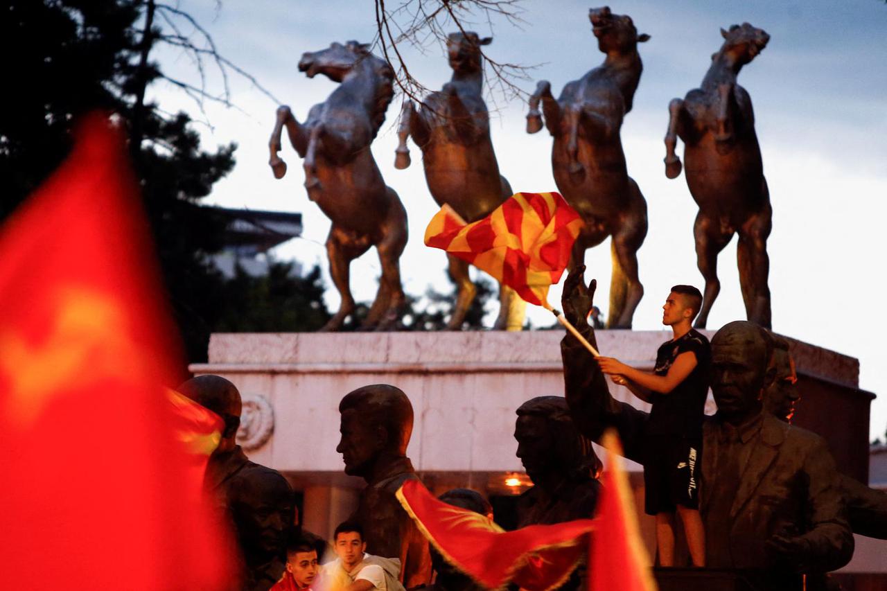 A supporter of VMRO-DPMNE waves a flag while rallying, in Skopje
