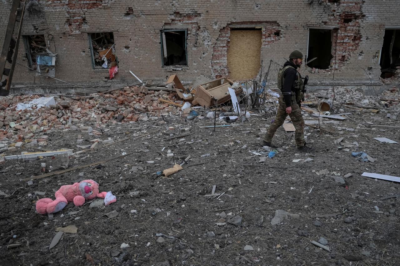 A Ukrainian serviceman walks near destroyed building in the frontline town of Chasiv Yar
