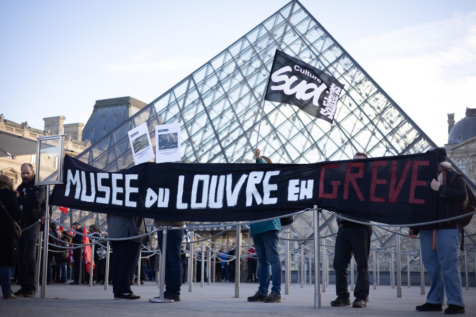 Museum staff hold banners outside the Pyramid of the Louvre Museum as workers voted to go on strike against increasingly deteriorating working conditions and the declining visitor experience at the world famous museum, in Paris on December 15, 2025. Photo by Raphael Lafargue/ABACAPRESS.COM Photo: Lafargue Raphael/ABACA/ABACA
