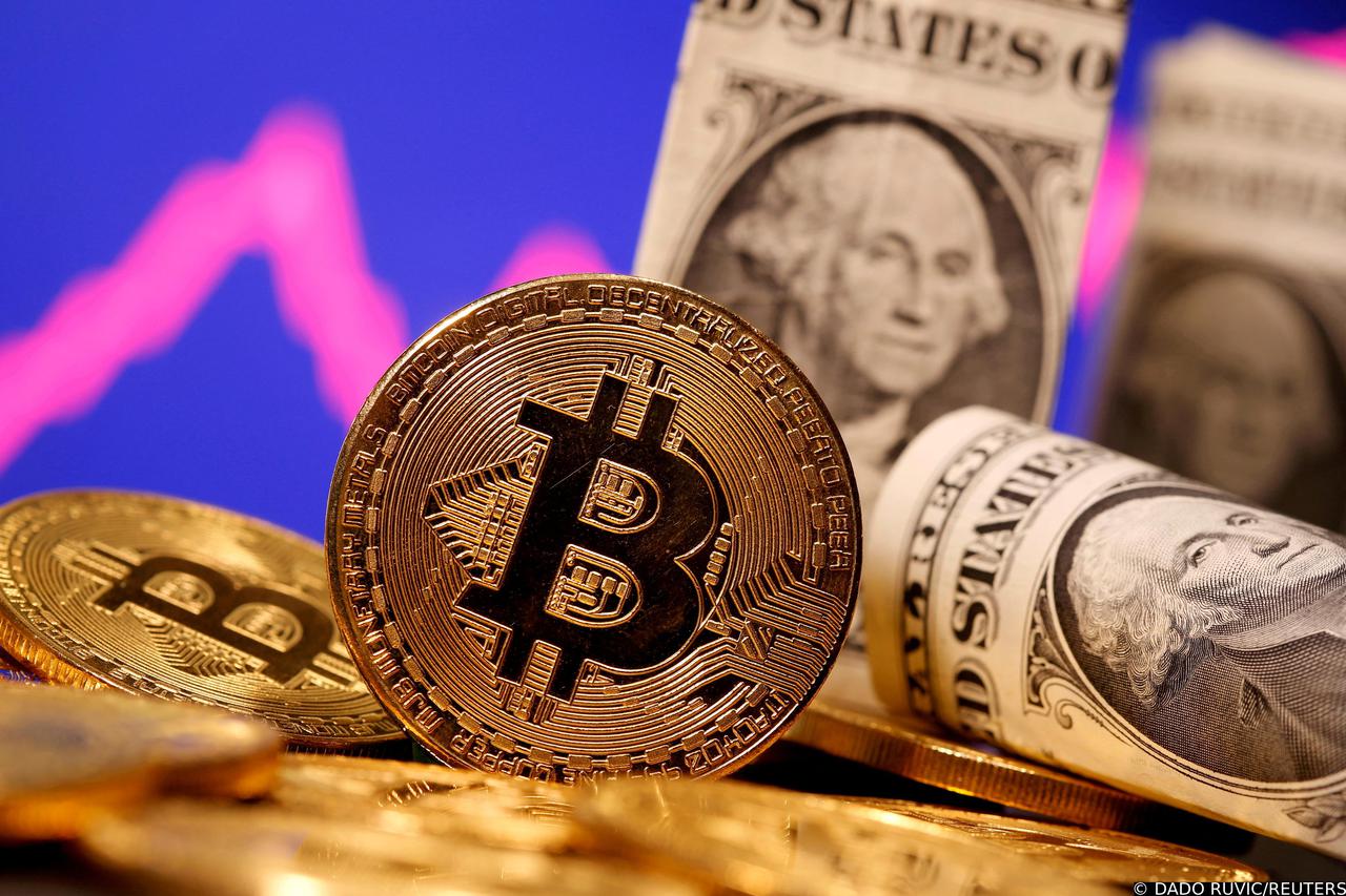 FILE PHOTO: FILE PHOTO: A representation of virtual currency Bitcoin and U.S. One Dollar banknotes are seen in front of a stock graph in this illustration