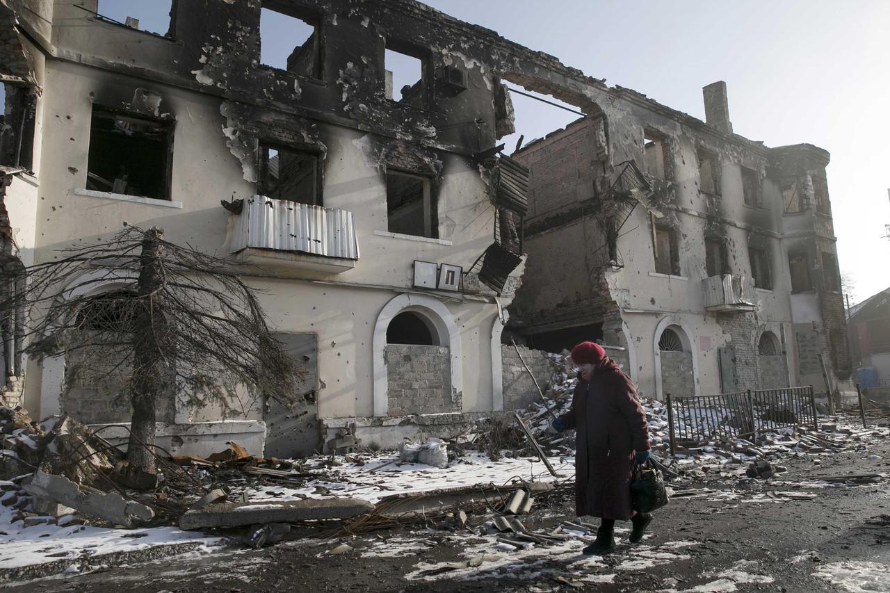 ATTENTION EDITORS - REUTERS PICTURE HIGHLIGHT TRANSMITTED BY 0610 GMT ON FEBRUARY 15, 2015   BAZ005 A woman walks past a damaged building in the town of Vuhlehirsk near Donetsk, Ukraine, February 14, 2015.  REUTERS/Baz Ratner   REUTERS NEWS PICTURES HAS N