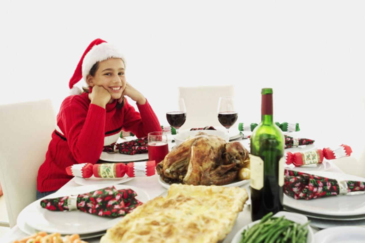 'christmas buffet on the table with a boy sitting wearing a christmas cap'