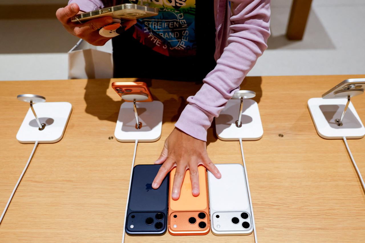 A customers take photos of the Apple’s new iPhone 17 on the first day of sales at an Apple Store in Taipei