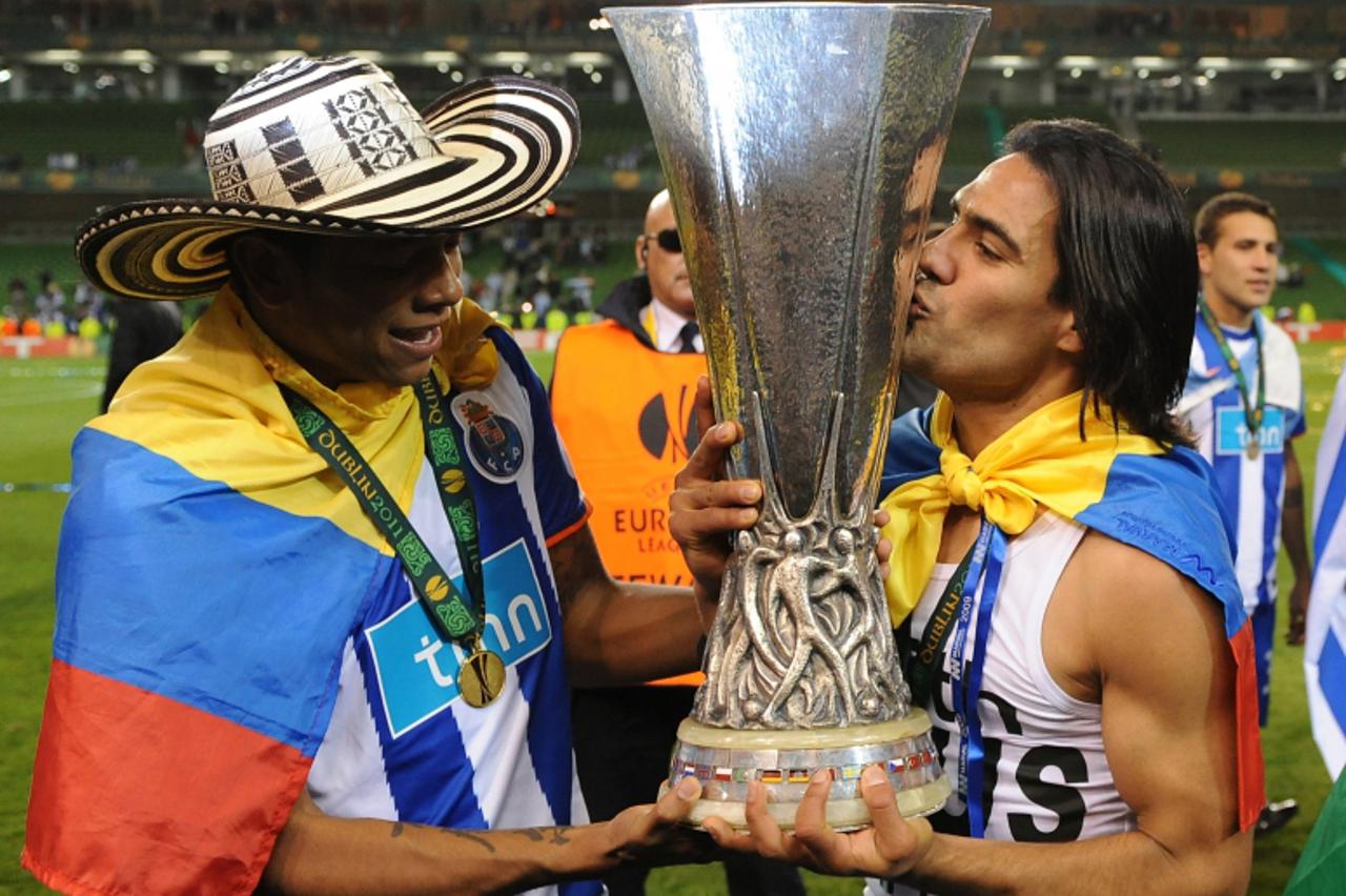 'FC Porto\'s Colombian forward Falcao (R) kisses the  trophy as he celebrates their victory with teammate Colombian midfielder Fredy Guarin (L) at the end of the UEFA Europa League final football matc