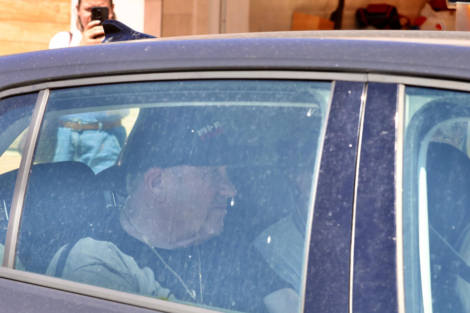 Dok je u automobilu prolazio pored fotoreportera digao je ruke u zrak kako bi pokazao lisice. Usput se smješkao.