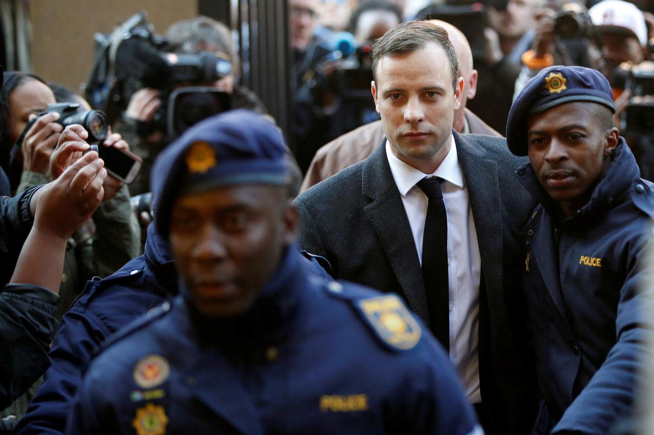 FILE PHOTO: Olympic and Paralympic track star Oscar Pistorius is escorted by police officers as he arrives for his sententencing for the 2013 murder of his girlfriend Reeva Steenkamp, at North Gauteng High Court in Pretoria
