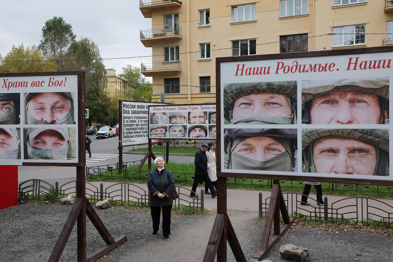 Russian soldiers' portraits and a military vehicle displayed in a street in St Petersburg