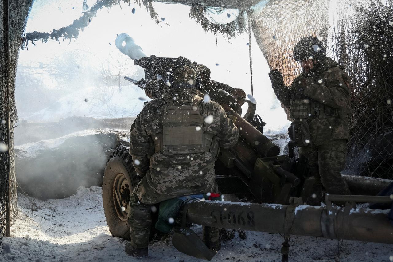 Ukrainian service members fire a L119 howitzer towards Russian troops near the front line town of Marinka