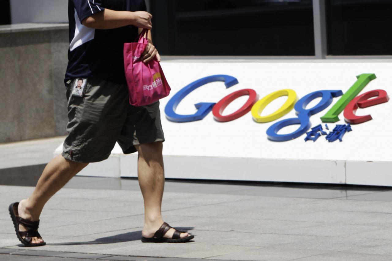 'An employee walks past the logo of Google in front of its former headquarters, in Beijing June 2, 2011. Hackers who broke into Google\'s Gmail system had access to some accounts for many months and c