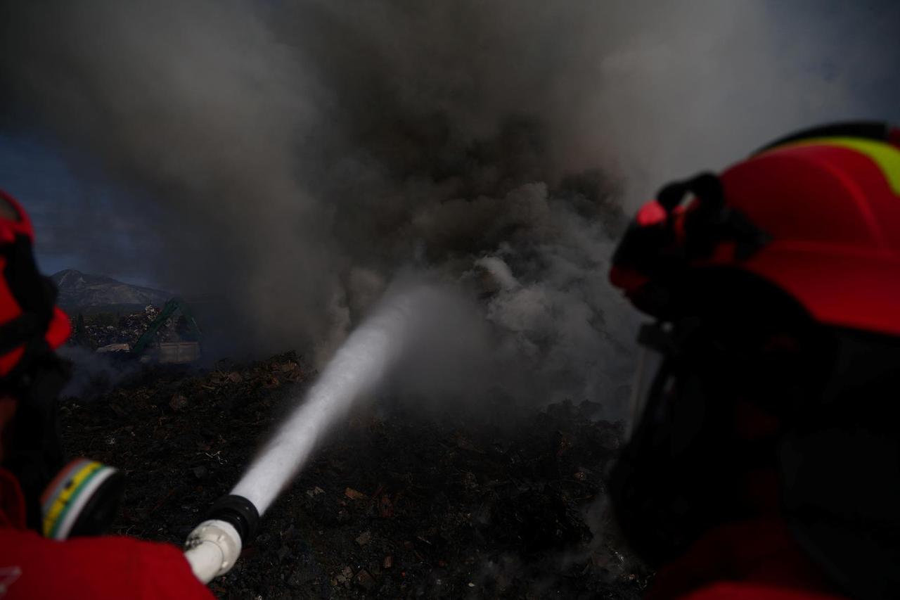 Military members of emergency services try to extinguish a fire at a metal recycling centre in Elbasan
