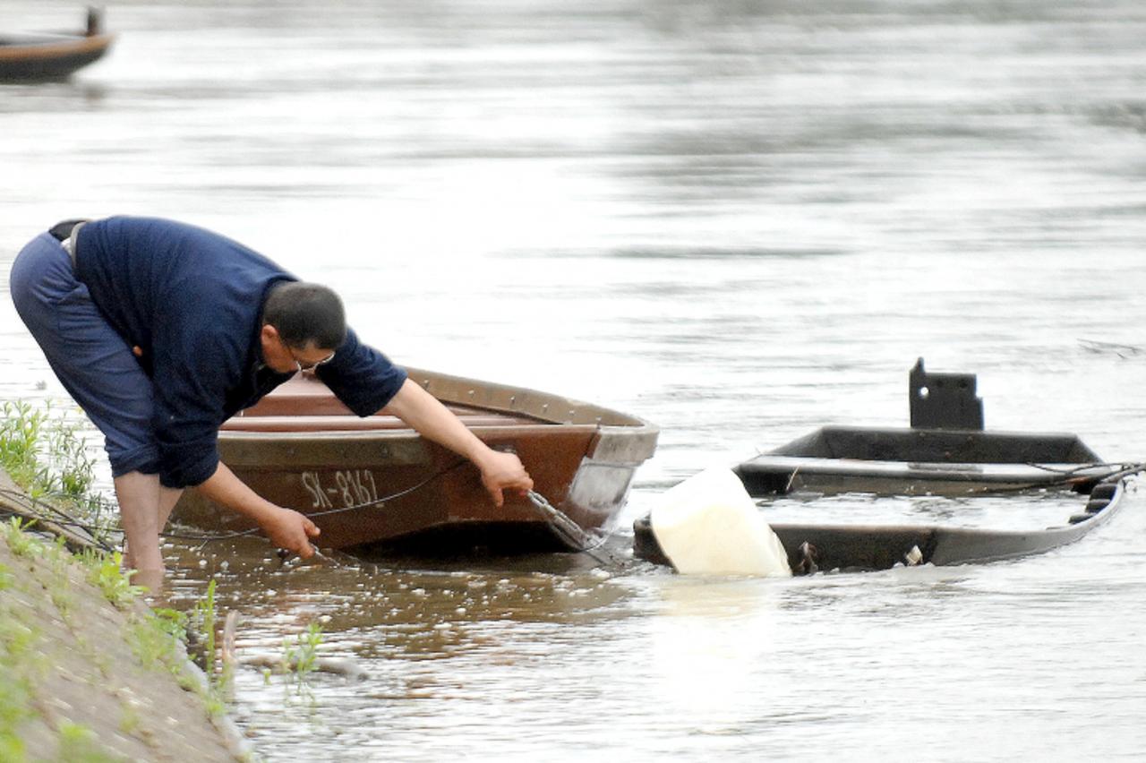 'sisak - 03.06.2010., Sisak - Kise koje padaju zadnjih dana zadale su dosta brige vlasnicima camaca usidrenih na obali KUpe. Dosta ih je potopljeno, pa vlasnici pokusavaju sve kako bi ih spasili od rj