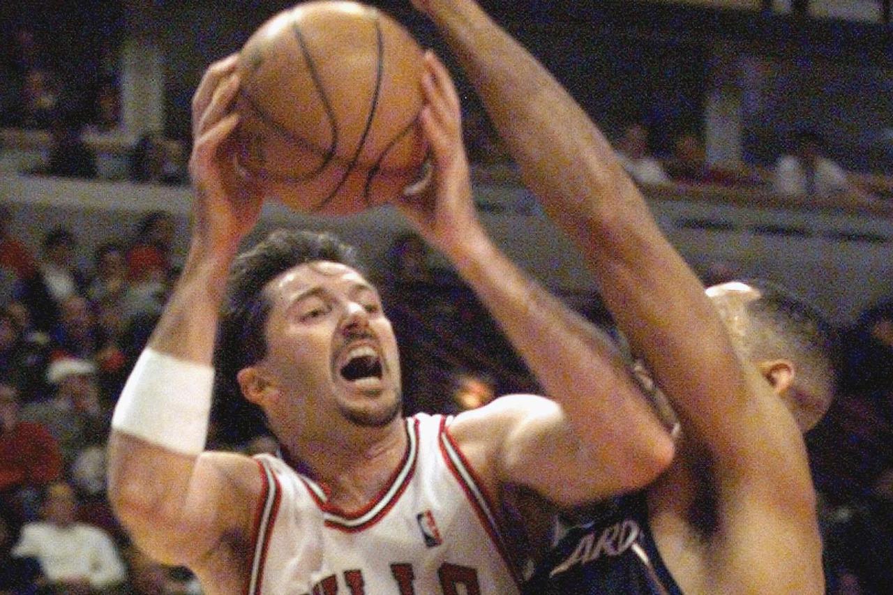 Chicago Bulls' Toni Kukoc (L) looks for an opening past Washington Wizards' Juwan Howard during third quarter action January 5 at Chicago's United Center. Kukoc was activated against the Wizards after missing the last 24 games due to back spasms.  SJO/SV
