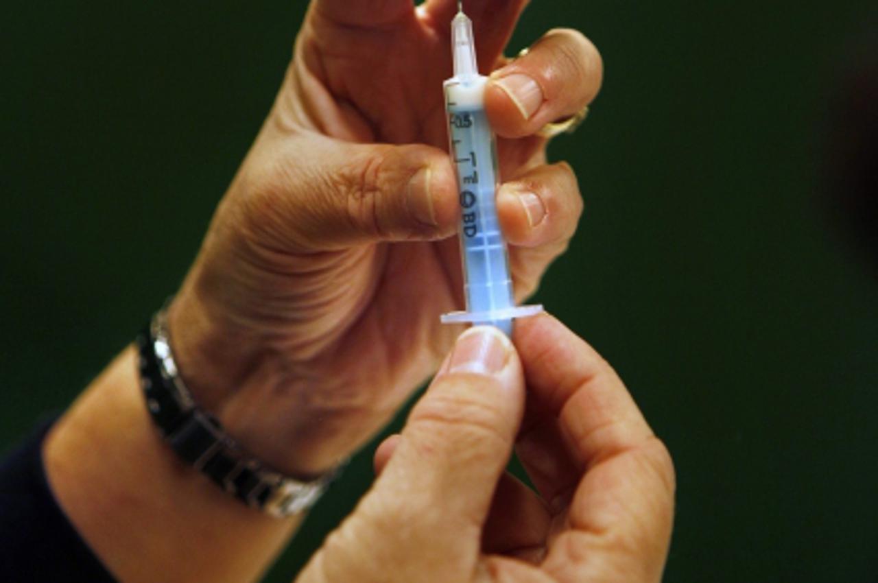 'A syringe is filled with the vaccine against the H1N1 virus during a vaccination programme in Schiedam November 23, 2009.  Vaccination programmes against H1N1 have started in many European countries 