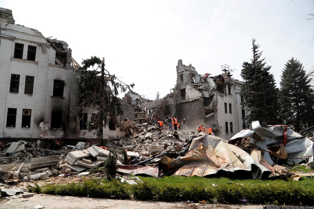 FILE PHOTO: People remove the debris of a theatre building in Mariupol