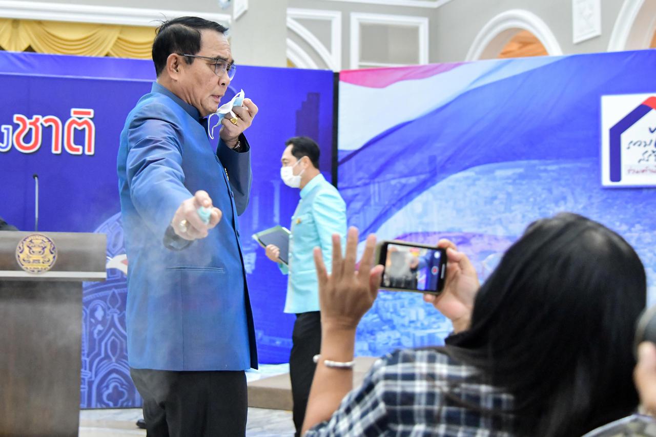 Thai Prime Minister Prayuth Chan-ocha sprays hand sanitizer at front row journalists to avert answering questions on the latest Cabinet reshuffle in Bangkok