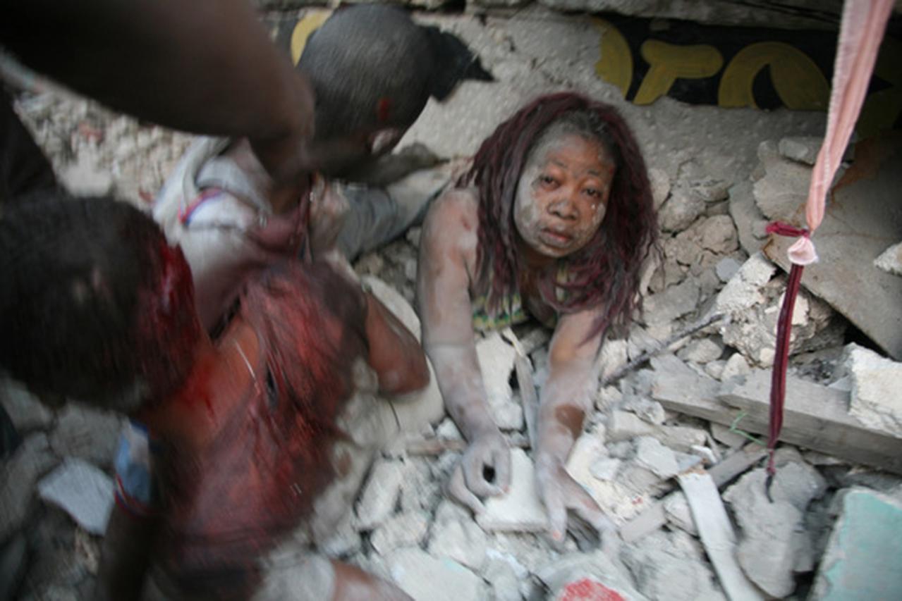 'A Haitian woman is covered in rubble on January 12, 2010 in Port-au-Prince after a huge earthquake measuring 7.0 rocked the impoverished Caribbean nation of Haiti, toppling buildings and causing wide