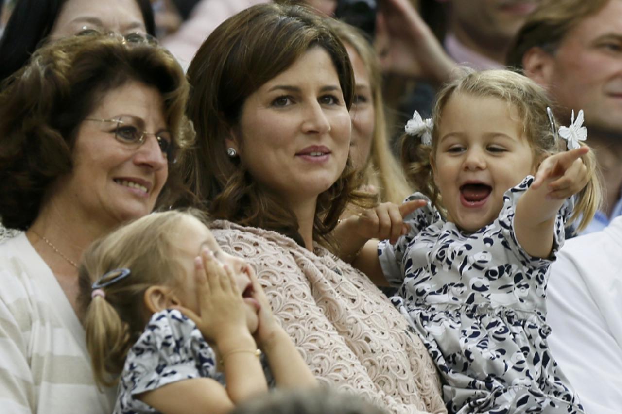 'The wife of Roger Federer of Switzerland, Mirka Federer (C) with their two-year-old twins Charlene Riva and Myla Rose, celebrates after Federer defeated Andy Murray of Britain in their men\'s singles