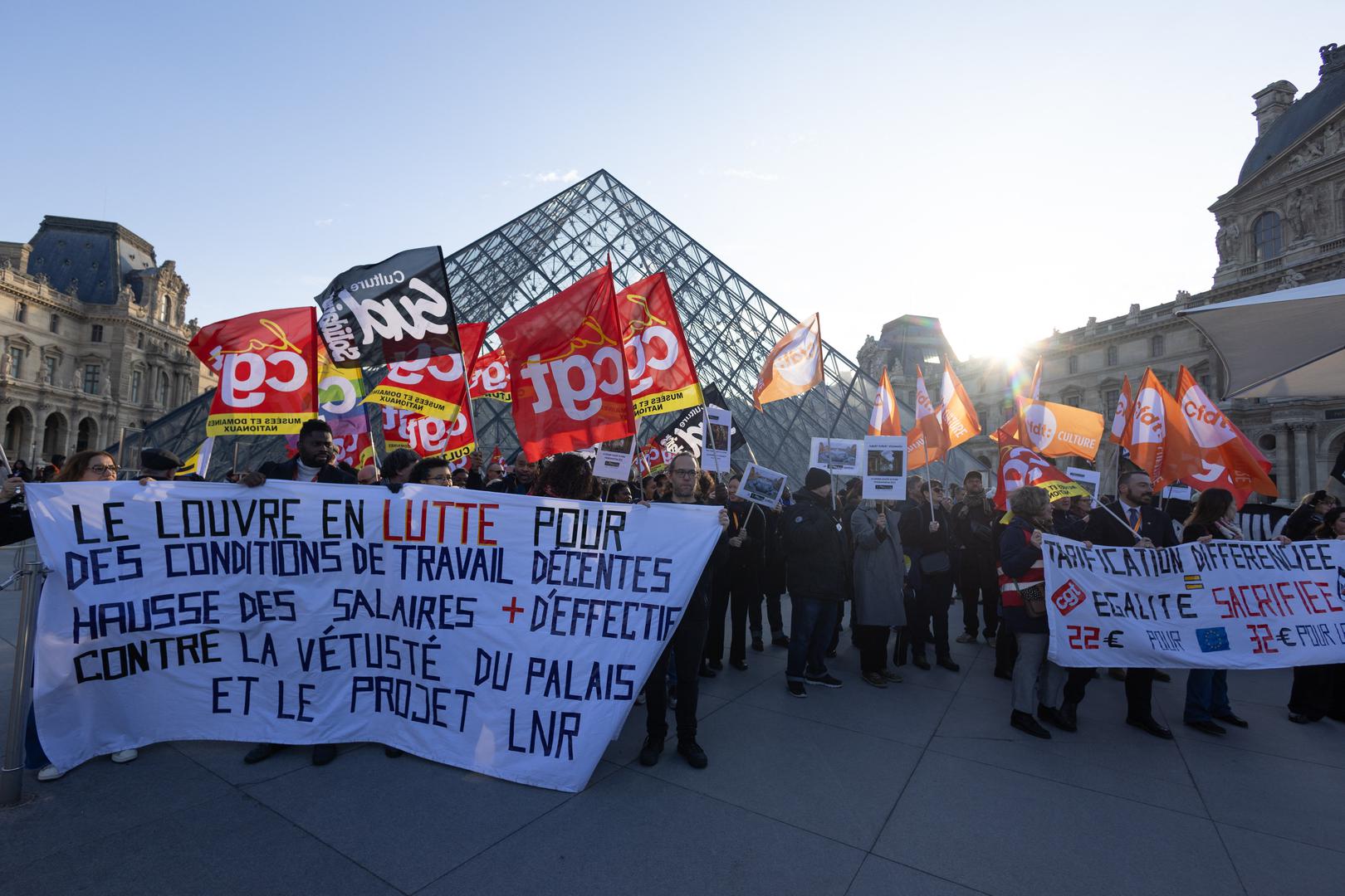Museum staff hold banners outside the Pyramid of the Louvre Museum as workers voted to go on strike against increasingly deteriorating working conditions and the declining visitor experience at the world famous museum, in Paris on December 15, 2025. Photo by Raphael Lafargue/ABACAPRESS.COM Photo: Lafargue Raphael/ABACA/ABACA
