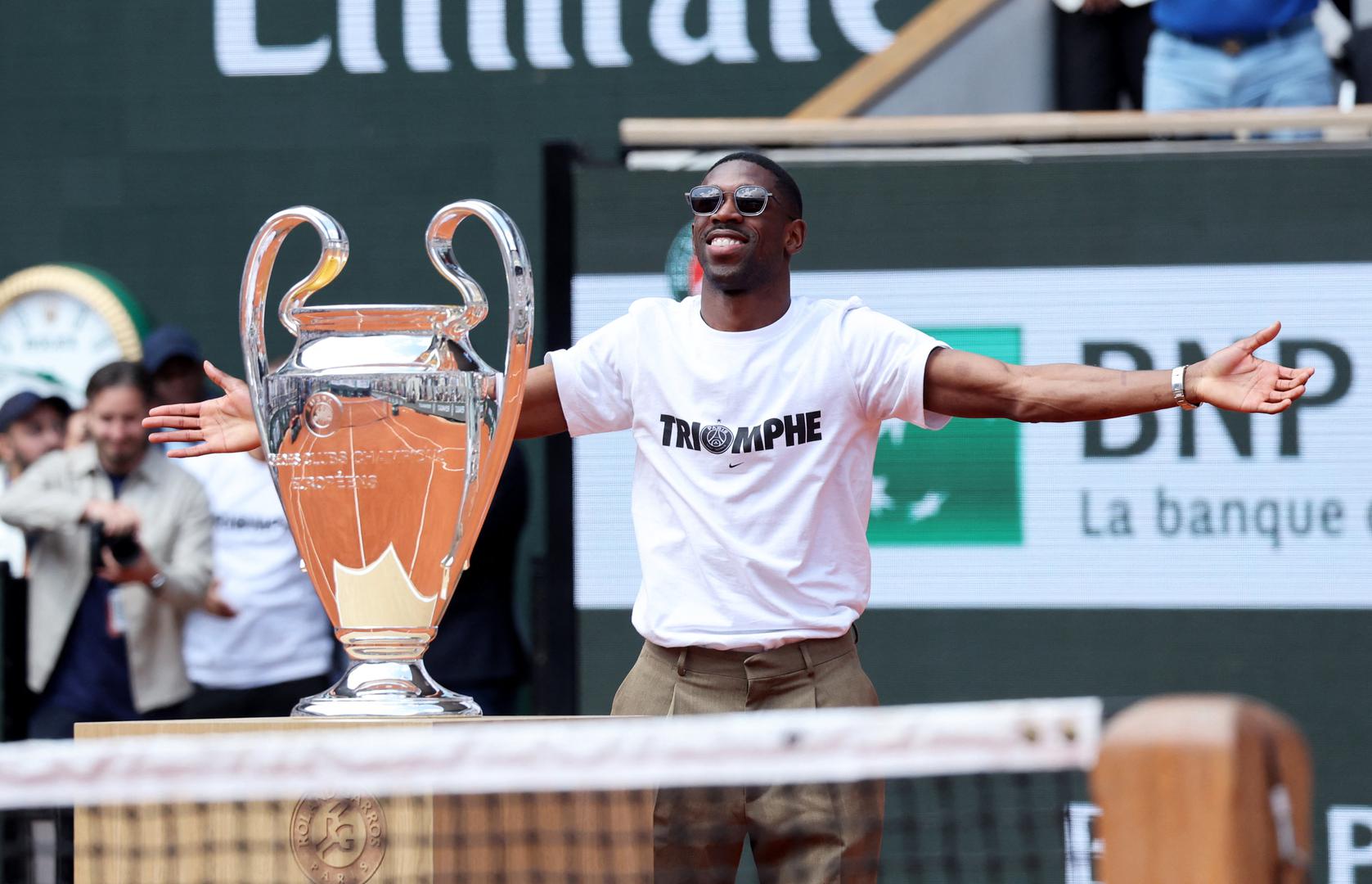 Svečanost za Dembelea, koji je proglašen igračem sezone Lige prvaka, nastavila se u ponedjeljak kada je pred više od 10.000 ljudi donio sjajni trofej na teren Philippe Chatrier.Nosio je bijelu majicu s natpisom "trijumf".