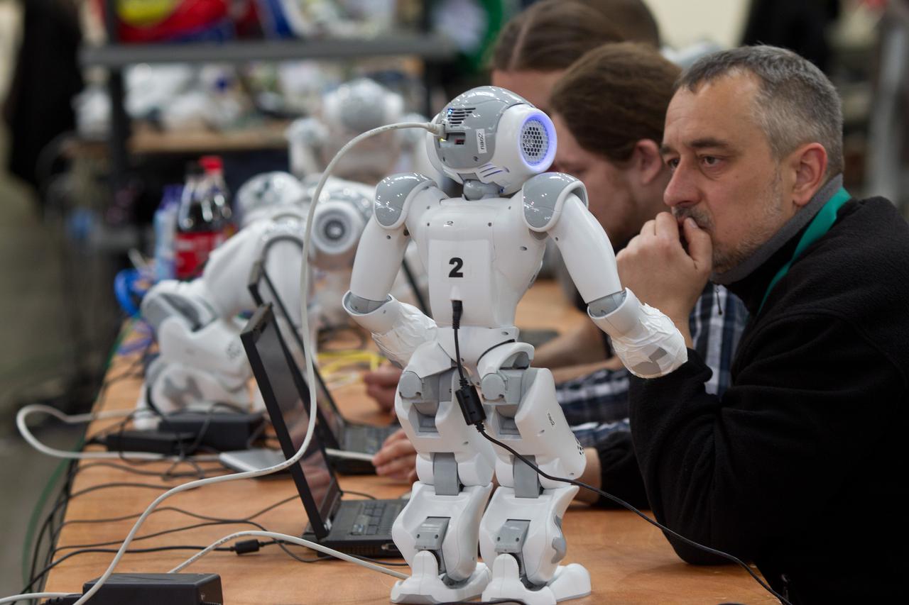 People prepare their robots of the category 'Standard Platform League' for the Robo-Cup German Open 2012 in Magdeburg, Germany, 30 March 2012. About 200 teams and more than 800 active participants take part in the competition of creations of artificial in