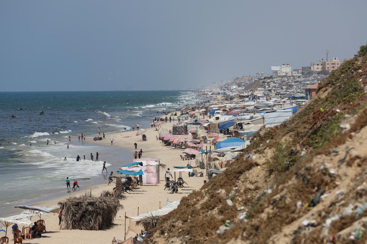 Displaced Palestinians shelter on a beach, in Deir Al-Balah in the central Gaza Strip
