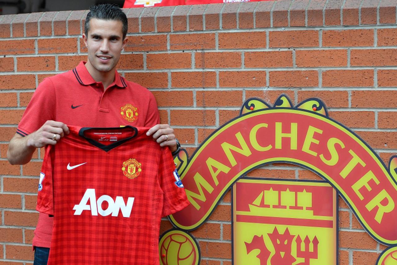 'Manchester United new signing Robin Van Persie poses at Old Trafford in Manchester, north-west England on August 17, 2012, Van Persie signed from Arsenal for £24,000,000 (30527202 euros) on a four ye