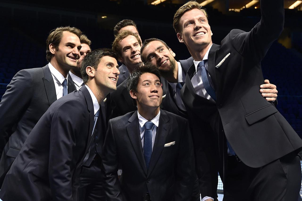 Tomas Berdych (R) takes a 'selfie' with fellow tennis players (L-R) Roger Federer, Stan Wawrinka, Novak Djokovic, Andy Murray,  Milos Raonic, Kei Nishikori and Marin Cilic at the O2 Arena in London November 7, 2014. The men's ATP World Tour tennis finals 