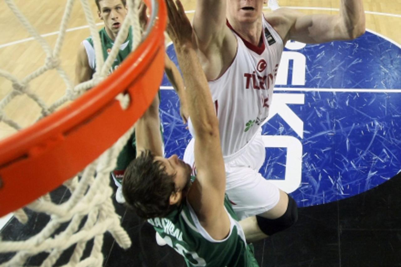 'Turkey\'s Omer Asik (C) goes up to shoot against Slovenia\'s Bostjan Nachbar during their FIBA Basketball World Championship game in Istanbul September 8, 2010.                REUTERS/Sergio Perez (T