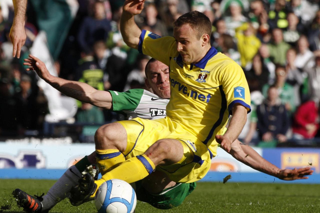 \'Celtic\'s Scott Brown tackles Kilmarnock\'s Liam Kelly during their Scottish Communities League Cup final soccer match at Hampden Park stadium in Glasgow, Scotland March 18, 2012. REUTERS/David Moir