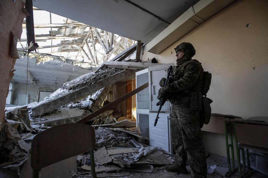 A Ukrainian serviceman is seen in a destroyed building of school at a frontline in Donetsk region | Autor : Stringer/REUTERS