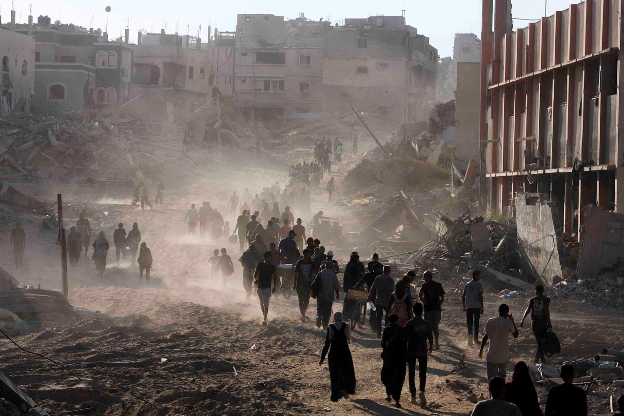 FILE PHOTO: Palestinians return to the eastern side of Khan Younis after Israeli forces pulled out from the area in Khan Younis, in the southern Gaza Strip