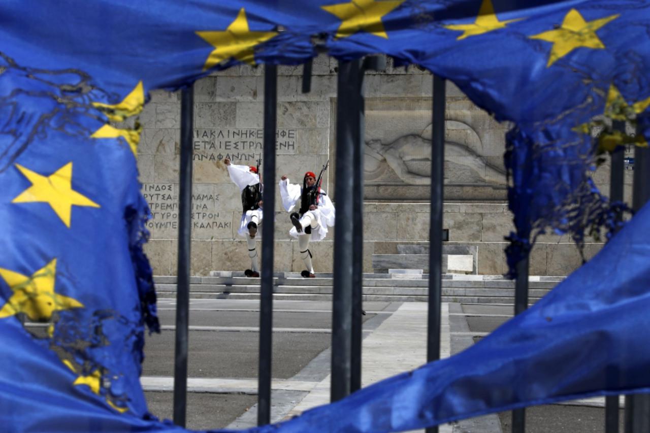 'Presidential guards are framed through a burned EU flag in front of the Tomb of the Unknown Soldier by the parliament in central Syntagma square in Athens May 1, 2013 following a May Day rally. Thous