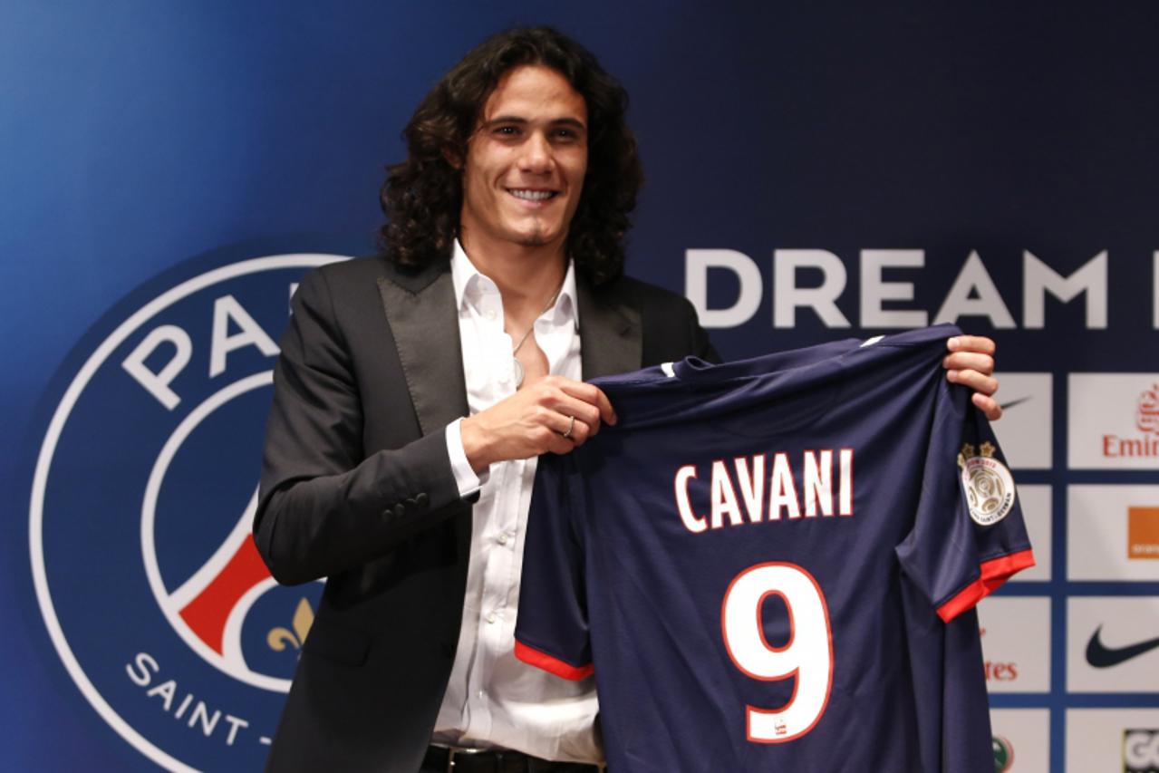 'Uruguay\'s soccer player Edinson Cavani presents his new jersey after a news conference at the Parc des Princes stadium in Paris July 16, 2013. Paris St Germain signed last season\'s Serie A top scor