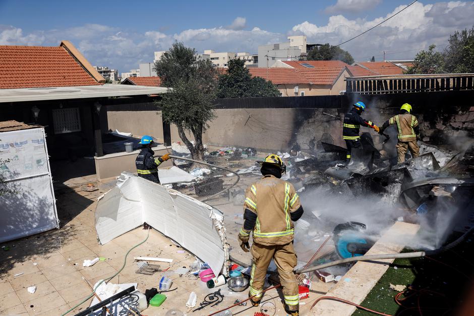 Israeli firefighters work after rockets launched from Gaza Strip into Israel in Sderot