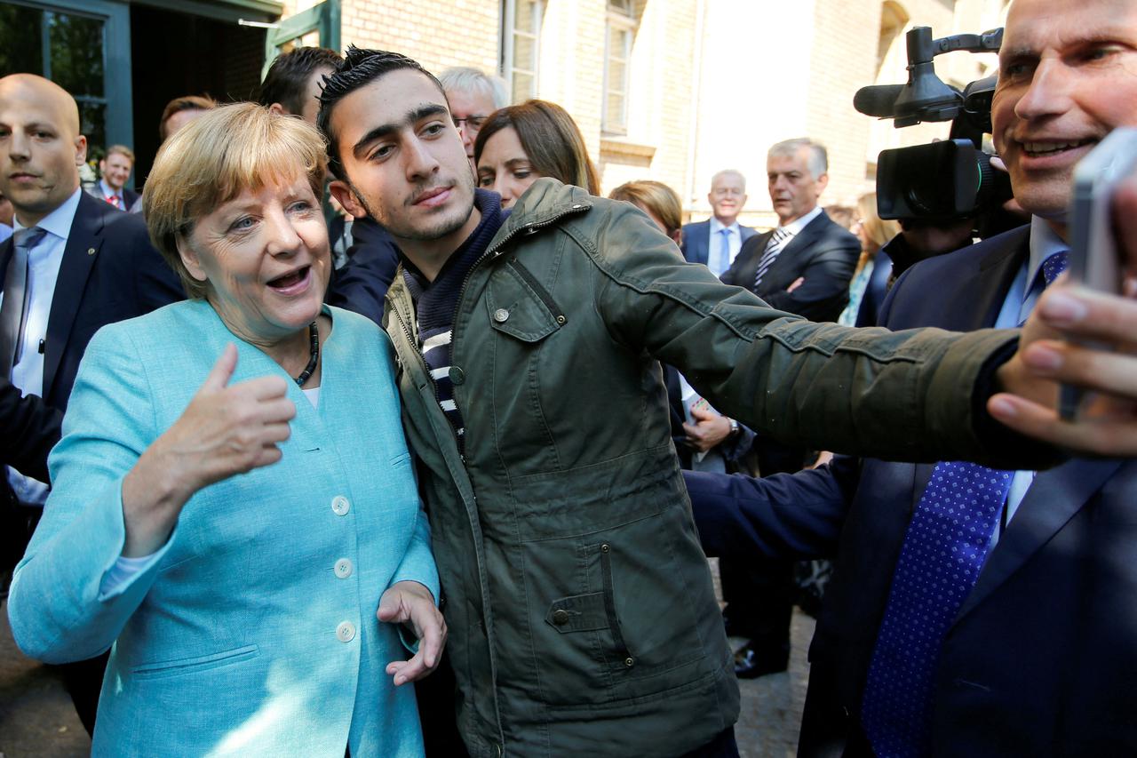 FILE PHOTO: Syrian refugee Anas Modamani takes a selfie with German Chancellor Angela Merkel outside a refugee camp near the Federal Office for Migration and Refugees after registration at Berlin's Spandau district