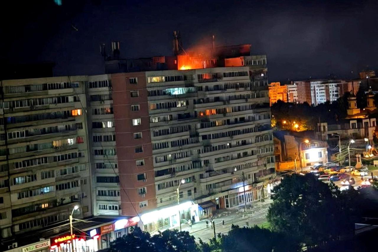 Fire burns on the roof of a 10-story block of flats after a drone crashed into the building in Galati