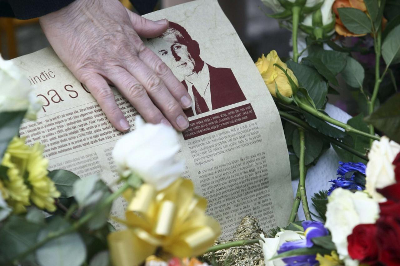 'A woman touches a picture of late Serbian prime minister Zoran Djindjic on his grave during a memorial service marking the 10th anniversary of his assassination in Belgrade March 12, 2013. Laying flo