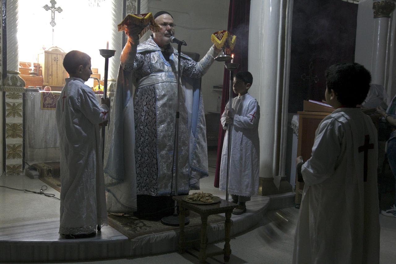 A priest celebrates a mass at the Syriac Orthodox Church in Al-Darbasiyah, Hasakah province November 13, 2013. Due to the clashes in north-eastern Syria, many Christians have fled the area seeking safety elsewhere, activists say. Picture taken November 13