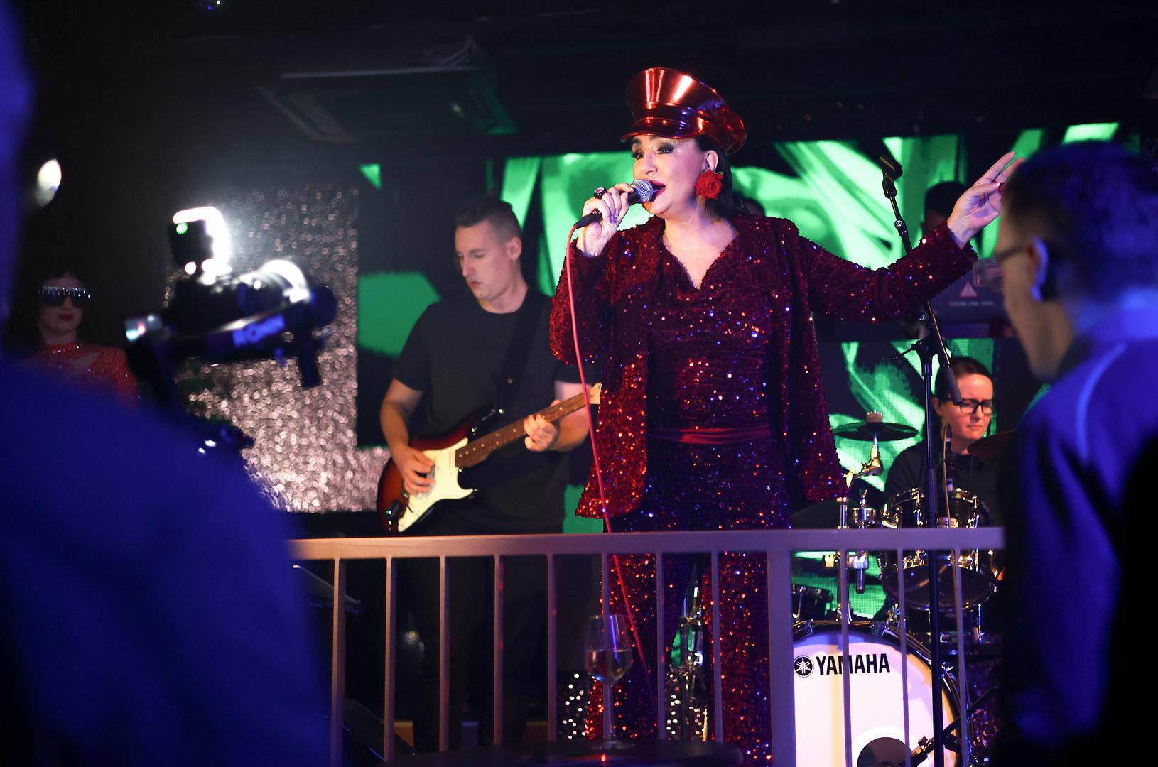 Tom prigodom odjenula je kompletnu crvenu kombinaciju koja uključuje šešir, hlače i sako prekrivene u šljokice.