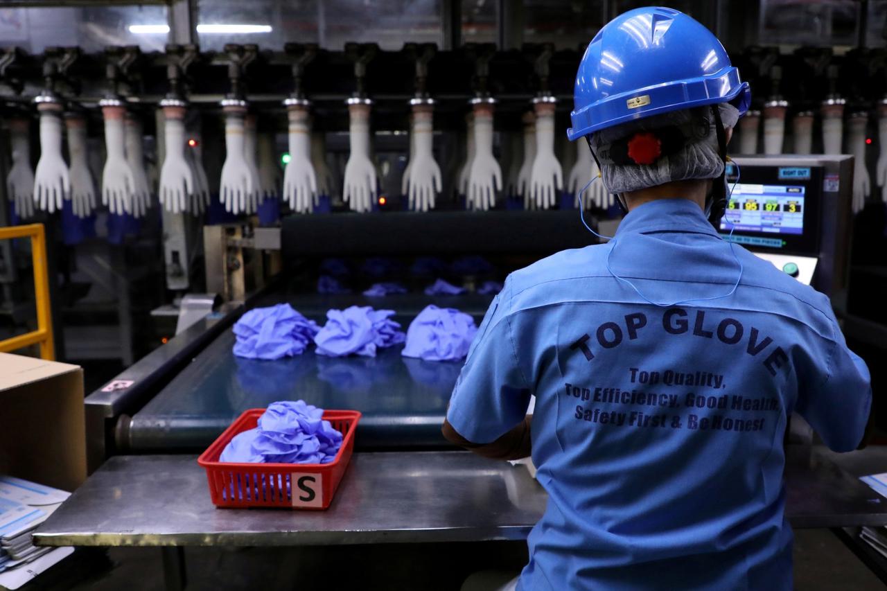 FILE PHOTO: A worker works at a production line in Top Glove factory in Shah Alam