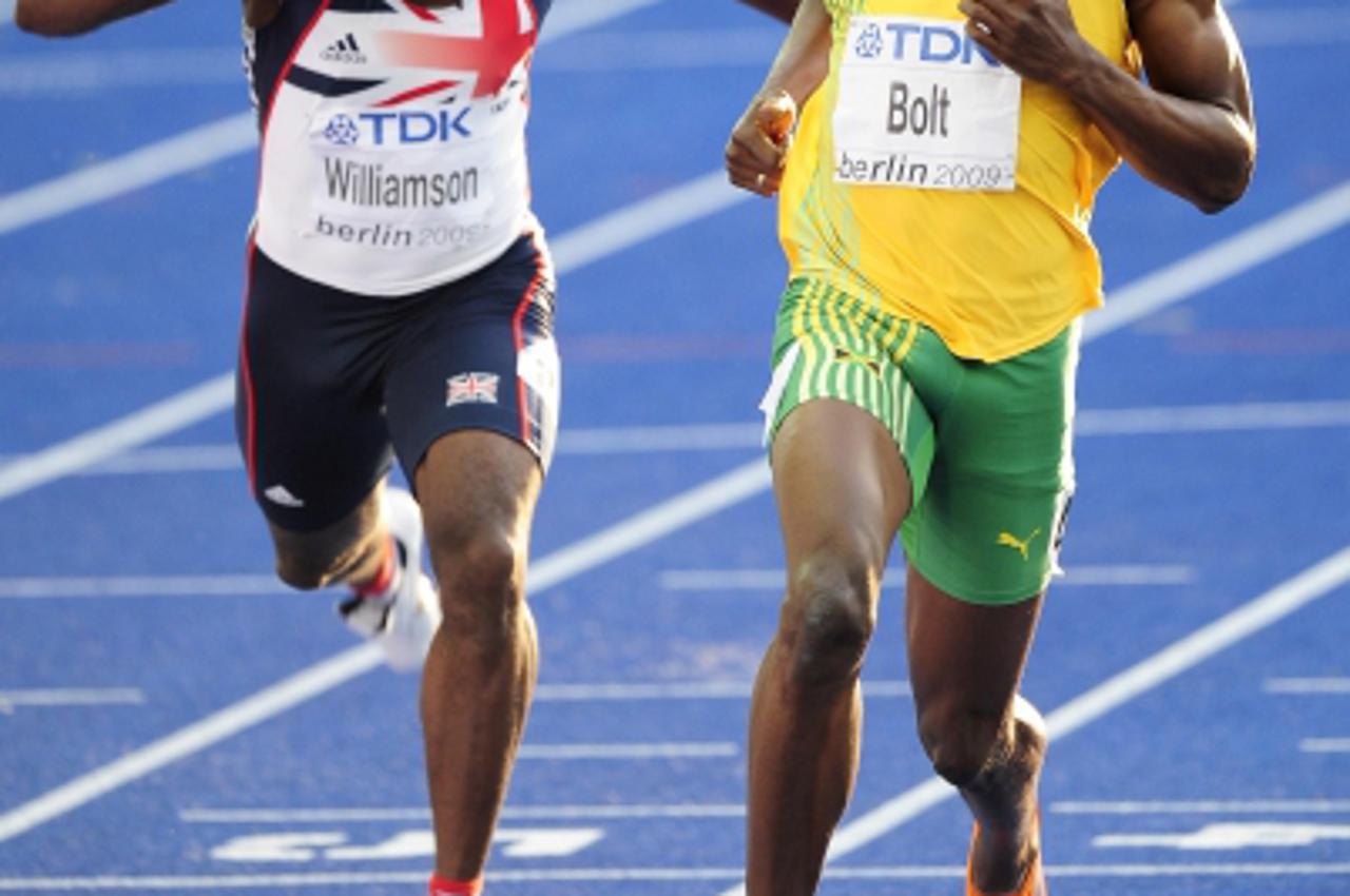 'Jamaica\'s Usain Bolt (right) smiles as he passes Great Britain\'s Simeone Williamson in the second round of the Mens 100m during the IAAF World Championships at the Olympiastadion, Berlin. Photo: Pr
