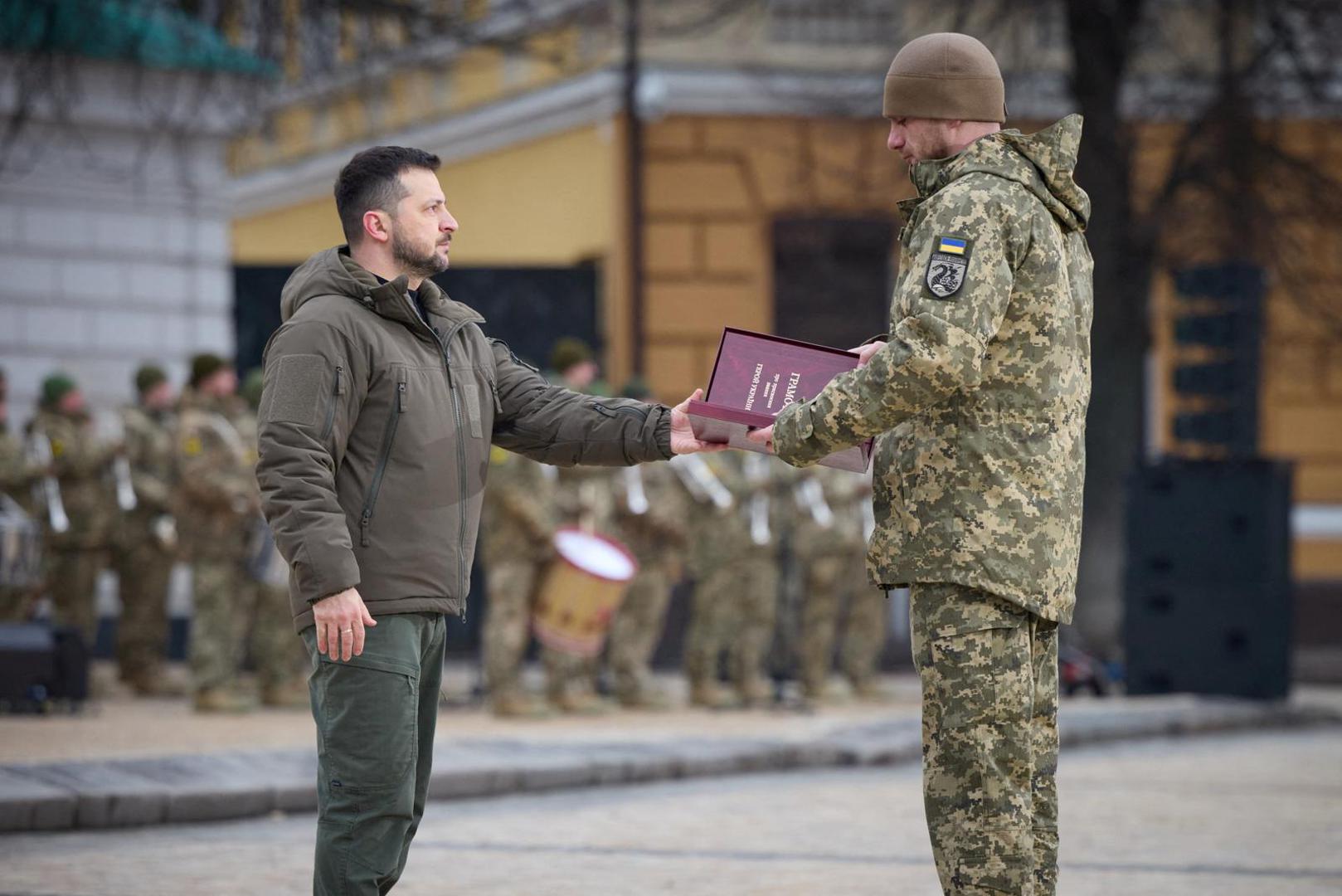Ukraine's President Volodymyr Zelenskiy handovers a flag to a serviceman during a ceremony dedicated to the first anniversary of the Russian invasion of Ukraine, amid Russia's attack on Ukraine, in Kyiv, Ukraine February 24, 2023. Ukrainian Presidential Press Service/Handout via REUTERS ATTENTION EDITORS - THIS IMAGE HAS BEEN SUPPLIED BY A THIRD PARTY. Photo: Ukrainian Presidential Press Ser/REUTERS