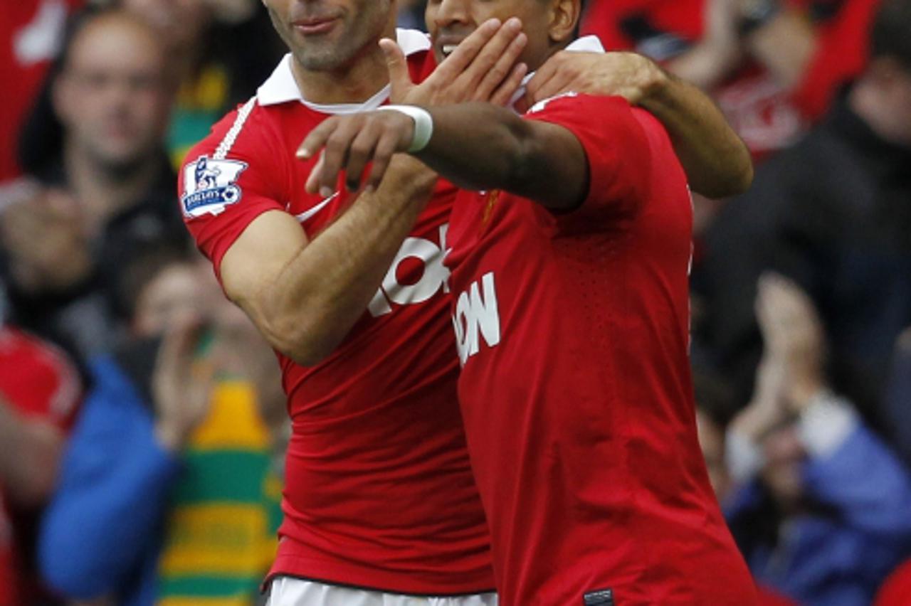'Manchester United\'s Portuguese midfielder Nani (R) celebrates scoring his goal with Welsh midfielder Ryan Giggs (L) during the English Premier League football match between Manchester United and Wes