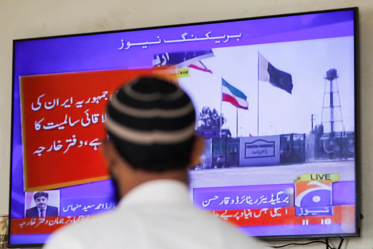 Man looks on television screen, after the Pakistani foreign ministry said the country conducted strikes targeting separatist militants inside Iran, in Karachi