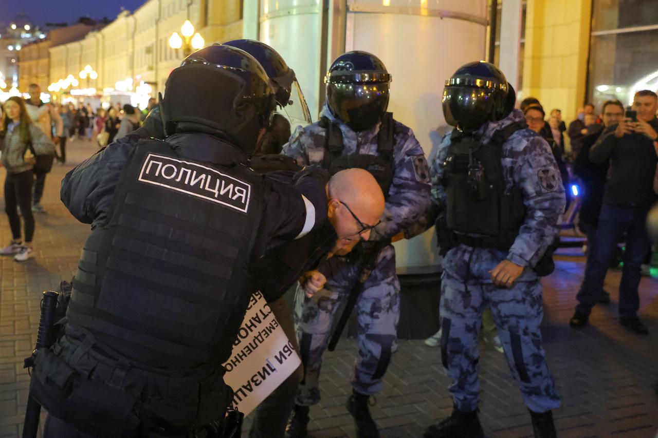 Russian police officers detain a participant during an unsanctioned rally in Moscow