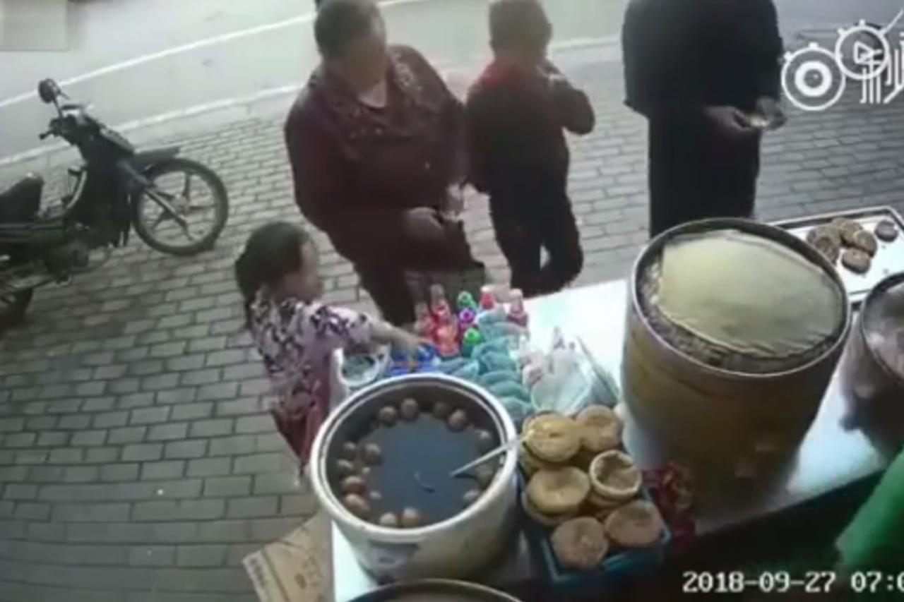 Djevojčica krade dok žena odvlači pozornost
