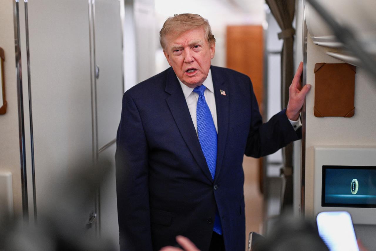 U.S. President Donald Trump speaks to the meadia aboard Air Force One