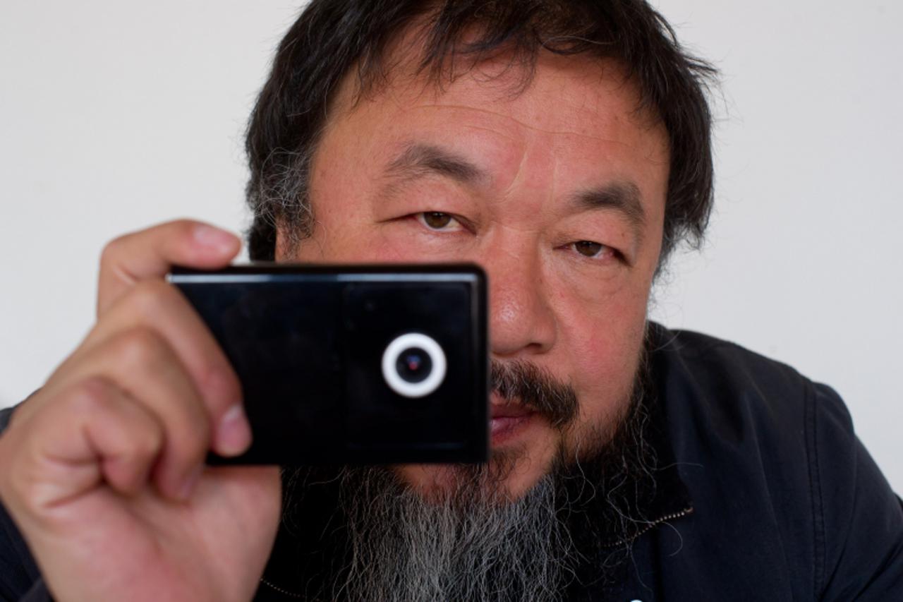 'Artist Ai Weiwei holds a webcam that he was reportedly ordered by Chinese police to disconnect, at his home in Beijing on April 5, 2012. Chinese artist and government critic Ai said he was ordered to