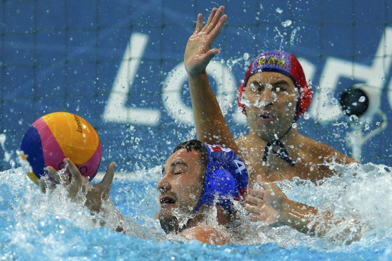 'Croatia\'s Dobud Niksa (L) controls the ball near the Kazakhstan goalkeeper Nikolay Maximov during their preliminary round Group A water polo match at the Water Polo Arena at the London Olympic Games